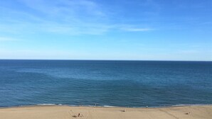 A beach with a clear view of the ocean and a sandy shore.