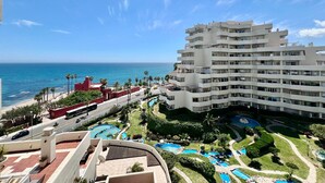 Un hôtel à étages, doté d’un espace piscine comprenant plusieurs piscines, et offrant une vue sur l’océan.
