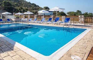 Een seizoensgebonden buitenzwembad, parasols voor strand/zwembad