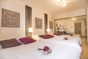 A hotel room with two beds, each with white linens and decorative pillows. There are wall art pieces and a mirror on the wall. - Shinsaibashi-House A (Osaka)
