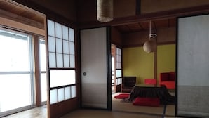 A traditional Japanese room with tatami flooring, a low wooden table, and a sliding door. - Akiu Canada (Sendai)