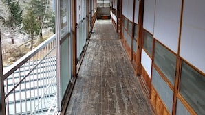A corridor with wooden floors and sliding doors on both sides. - Akiu Canada (Sendai)