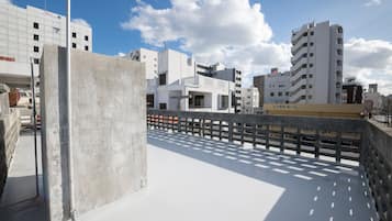 A modern building with a flat roof and a concrete barrier.