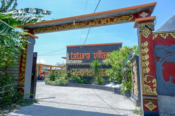 A traditional entrance with ornate decorations and a sign reading "tatura villa".
