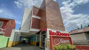 Edificio de RedDoorz Aksara Homestay con una entrada destacada y cielo despejado.