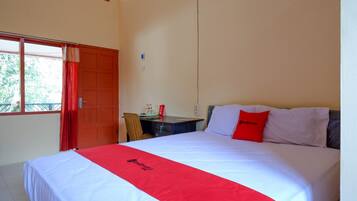 A hotel room with a bed, a desk, and a chair.