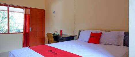 A hotel room with a bed, a desk, and a chair.