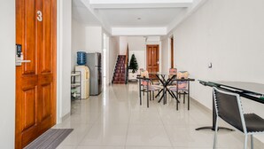 A modern kitchen with a refrigerator, a water dispenser, and a stove. - RedDoorz near UNTAG Surabaya (Surabaya)