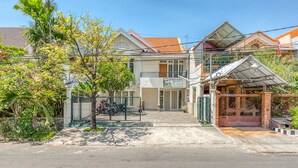 A two-story building with a gated entrance, a covered porch, and a visible signboard. - RedDoorz near UNTAG Surabaya (Surabaya)