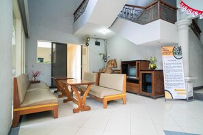 Un espacio habitable amplio con un sofá, una mesa de madera y un televisor.