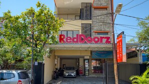A building with a sign reading "RedDoorz" and a covered entrance. - RedDoorz Syariah near Airlangga University Campus B (Surabaya)