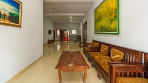 A spacious living area with a wooden coffee table, a sofa set, and a painting on the wall.