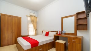 A bedroom with a wooden bed, a desk with a mirror, and a wardrobe.