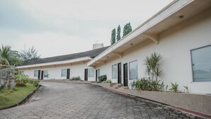 A modern building with a paved driveway leading to a series of rooms. - RedDoorz Premium @ Jalan Pal 10 Jambi (Jambi)
