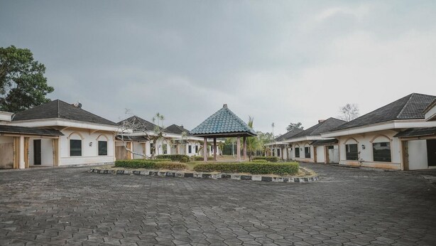 A courtyard with a gazebo, surrounded by buildings with uniform architecture. - RedDoorz Premium @ Jalan Pal 10 Jambi (Jambi)