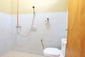 Ein kleines Badezimmer mit Toilette, Dusche und Toilettenpapierhalter.