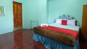 A bedroom with a bed, a wooden door, and a metal rack.