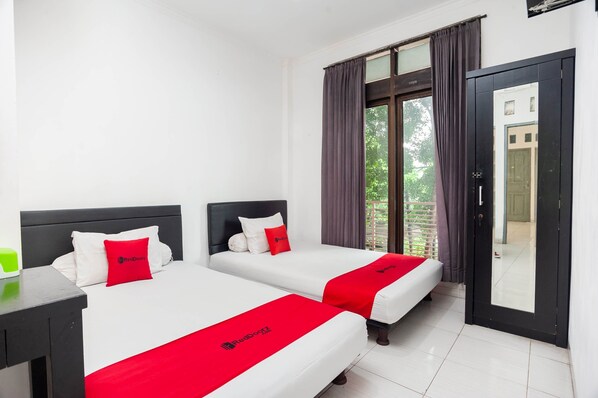 A hotel room with two beds, white bedding, red accents, a nightstand, a window with curtains, and a door leading to an outdoor area. - RedDoorz Syariah near Grand Galaxy Park (Bekasi)