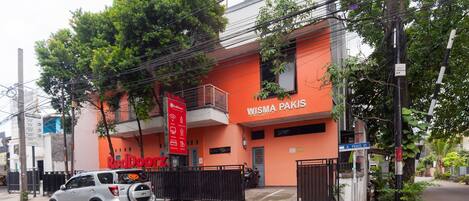 A building with a sign reading "WISMA PAKIS" and a parked car in front.