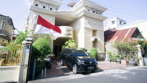 Un bâtiment avec un drapeau, une voiture et une porte.