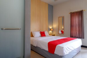A hotel room with a bed, a nightstand, a mirror, and a window with curtains. - RedDoorz Syariah near Alun Alun Tegal (Tegal)