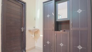 Une pièce avec une porte marron, un lavabo et une armoire ornée de motifs décoratifs.