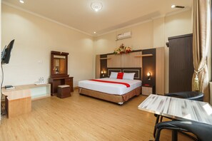 Una habitación de hotel con cama, escritorio, silla y una pequeña mesa.
