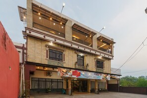 Un edificio de varios pisos con un letrero que anuncia desayuno, Wi-Fi y estacionamiento.
