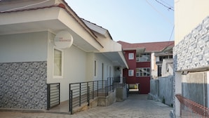 A residential building with a tiled walkway, a metal railing, and a sign indicating 'SAE Residences'. - Residences by RedDoorz near MT Haryono (Jakarta)