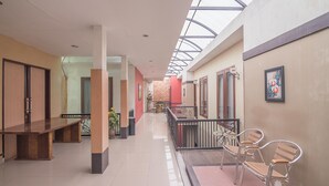 A corridor with a skylight, benches, and a railing.