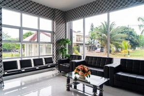 A modern waiting area with a glass coffee table, black leather sofas, and a bench with cushioned seats. - Formerly Reddoorz Plus Near Teras Kota 3 (South Tangerang)