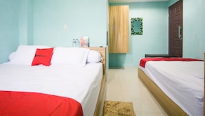 A hotel room with two beds, a wooden wardrobe, a small mirror, and a clock on the wall. - RedDoorz near Mikie Holiday Funland Berastagi (Berastagi)
