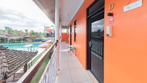 Uma varanda com vista para a piscina, um letreiro indicando 'Meu quarto' e uma porta identificada com a letra 'D'.