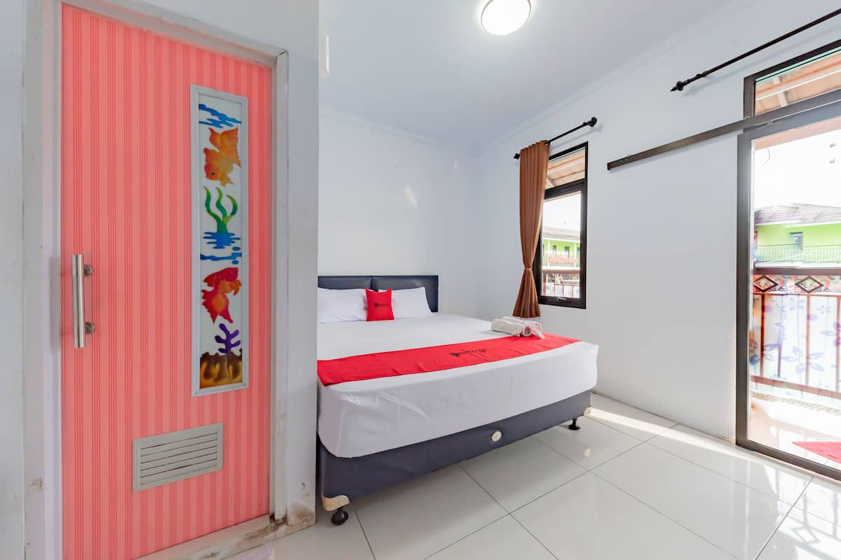 Een slaapkamer met een bed, een roze deur en een raam.