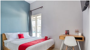 Une chambre à coucher avec un lit en bois, un bureau et une chaise.