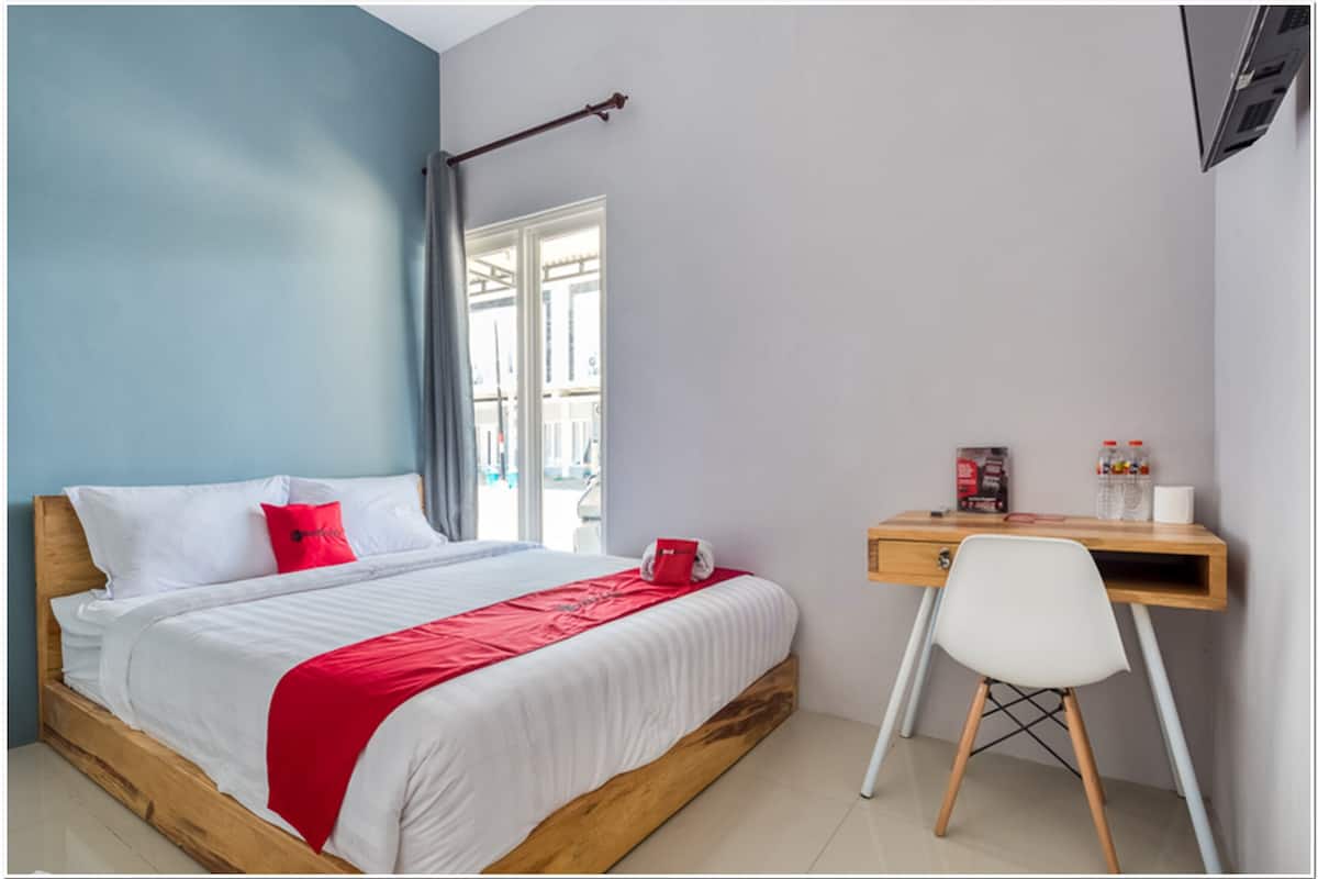 Ein Schlafzimmer mit einem hölzernen Bett, einem Schreibtisch und einem Stuhl.