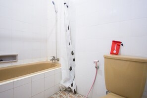 A bathroom with a bathtub, toilet, and shower curtain.