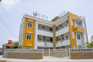 A multi-story building with balconies, a gated entrance, and a sign indicating it is a hotel. - Reddoorz Syariah Near Taman Pelangi Monjali (Ngaglik)
