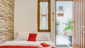 Ein Hotelzimmer mit einem Bett, einer roten Decke und einer Holzwand.