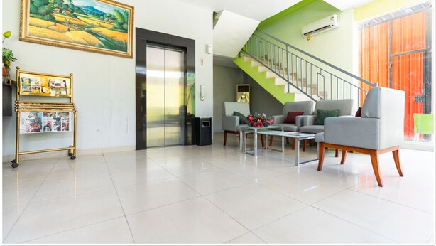 Una sala de estar moderna con una escalera, un cuadro y un atril para revistas.