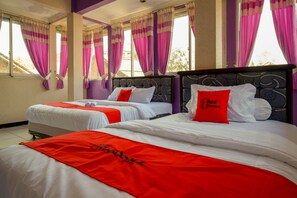 A hotel room with two beds, each with white bedding and red accents, including pillows and a blanket. The room has large windows with purple curtains and a view of the outside.