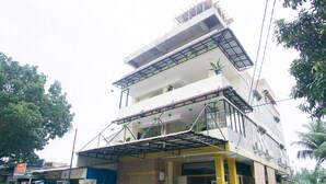 Een meerlaags gebouw met een overdekte ingang en een terras.