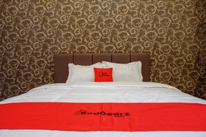 A hotel room with a patterned wallpaper, a brown headboard, white bedding, and a red blanket with the RedDoorz logo. - RedDoorz @ Jalan Pattimura Palu (Palu)