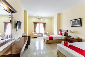 A hotel room with a bed, a desk, a chair, a TV, and a window with curtains. - RedDoorz Plus near Alun Alun Karanganyar (Karanganyar)