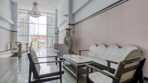 A spacious room with a long table, chairs, a sofa, and a decorative vase. - Formerly Reddoorz Plus Near Jakarta Kota Station (Jakarta)