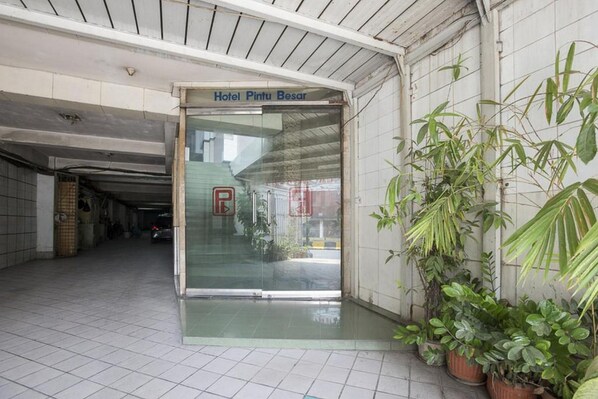 A hotel entrance with a glass door, a sign reading "Hotel Pintu Besar," and potted plants on the right. - Formerly Reddoorz Plus Near Jakarta Kota Station (Jakarta)
