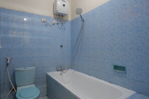 A bathroom with a toilet, a bathtub, and a shower.