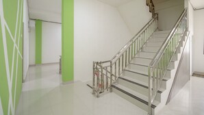 Una escalera con barandales metálicos y una pared de acento verde.