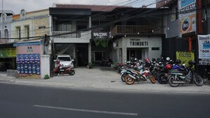 A row of motorcycles parked outside a building with a sign that reads "TOKO KOPUKTI". - RedDoorz Hostel @ Borobudur Street (Malang)