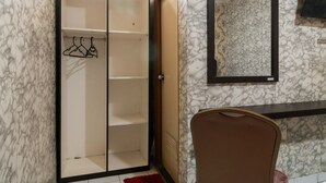 A room with a wardrobe, a mirror, and a chair. - RedDoorz near Tomang 2 (Jakarta)